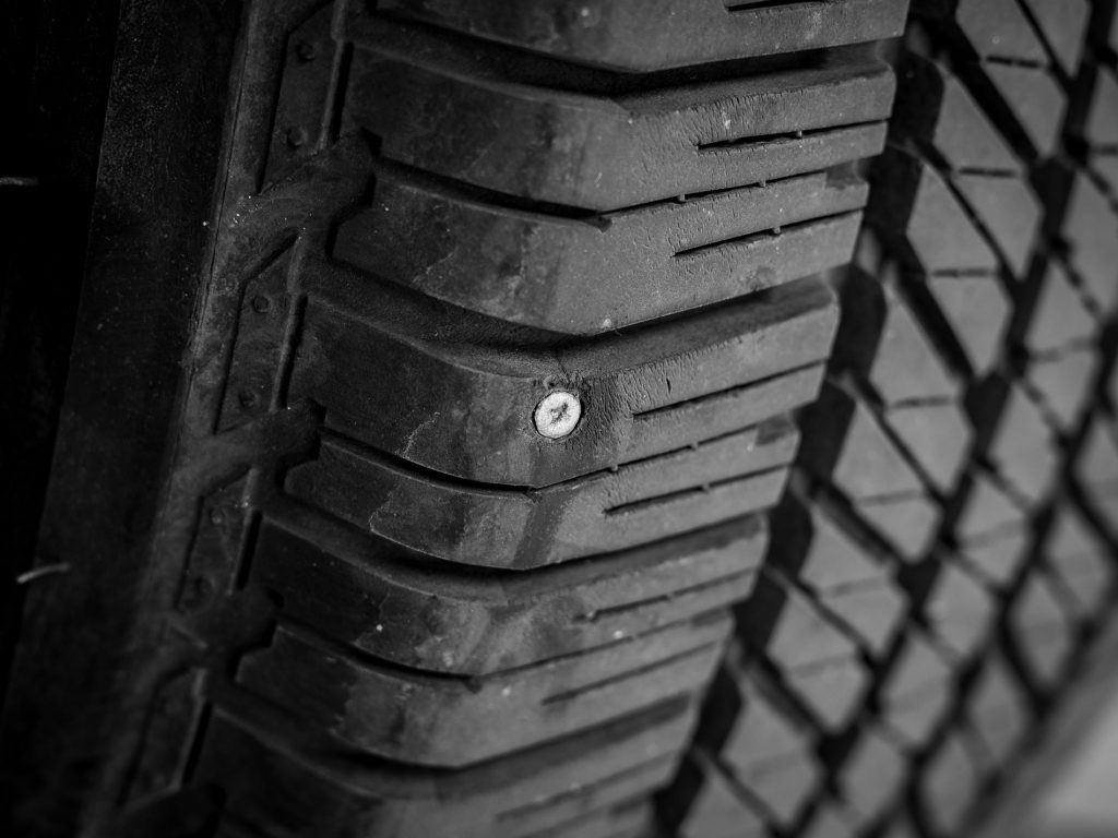 Nail stuck in a tyre, giving the tyre a puncture.