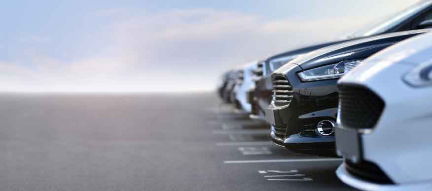 Row of cars, parked up in a car park.