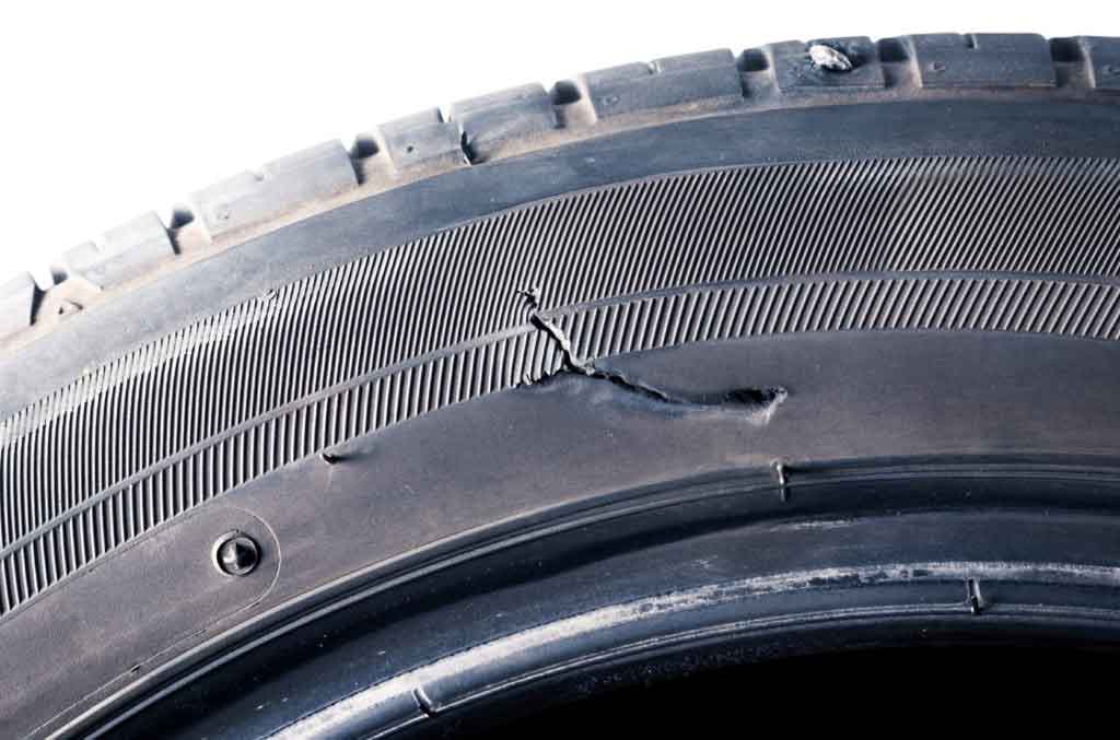 The car tyres have a tear/ crack on the sidewall and a nail stabbing at top